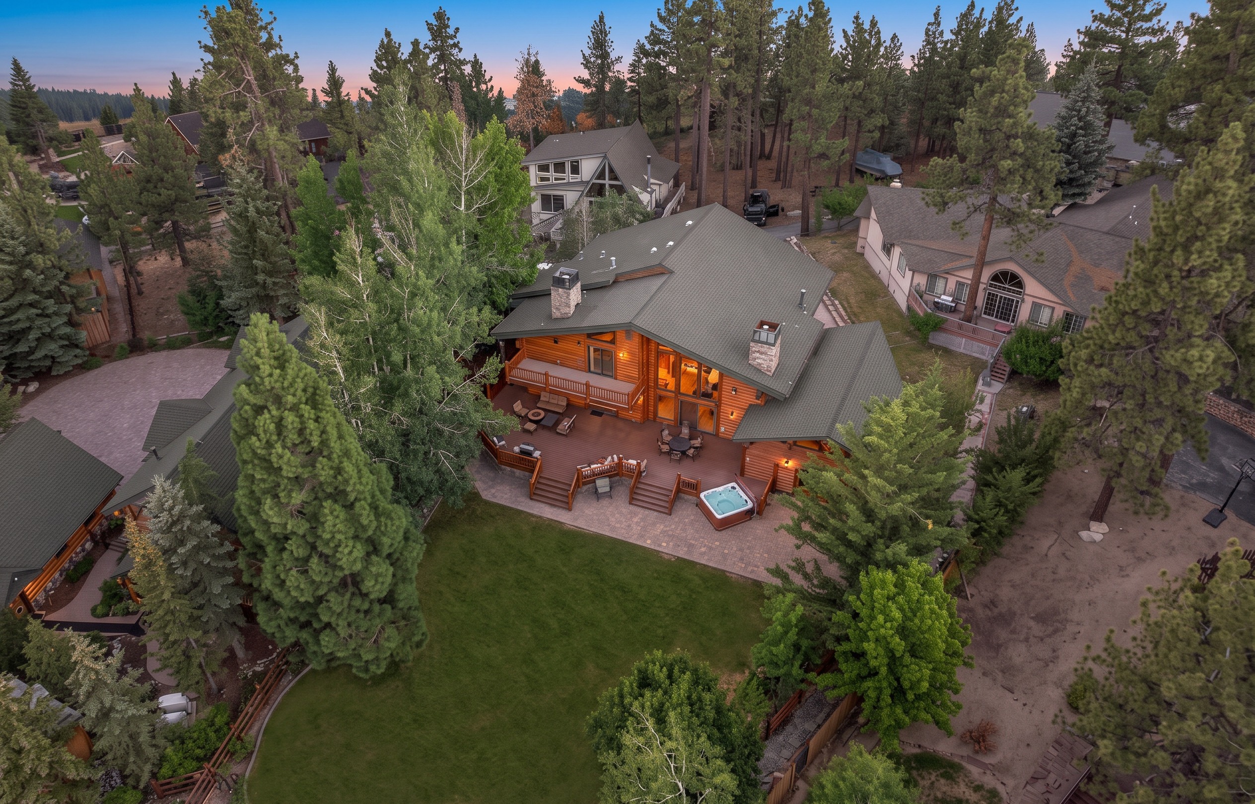 Aerial dusk view of Pleasure Point Lodge glowing above Big Bear Lake